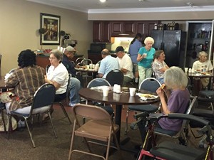 Seniors enjoying an event in a clubhouse. 